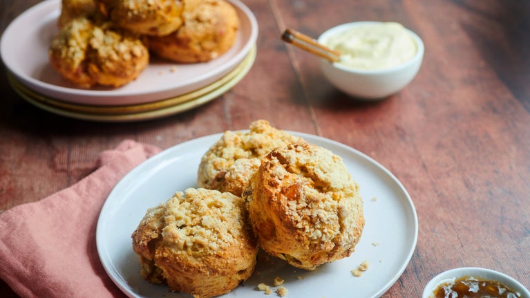 Scones with crumble topping on a plate with fillings in small pots